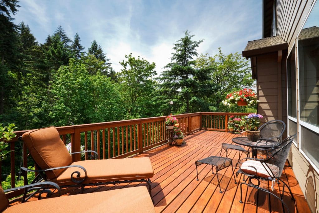 Deck stain sealer being applied with brush showing proper application technique