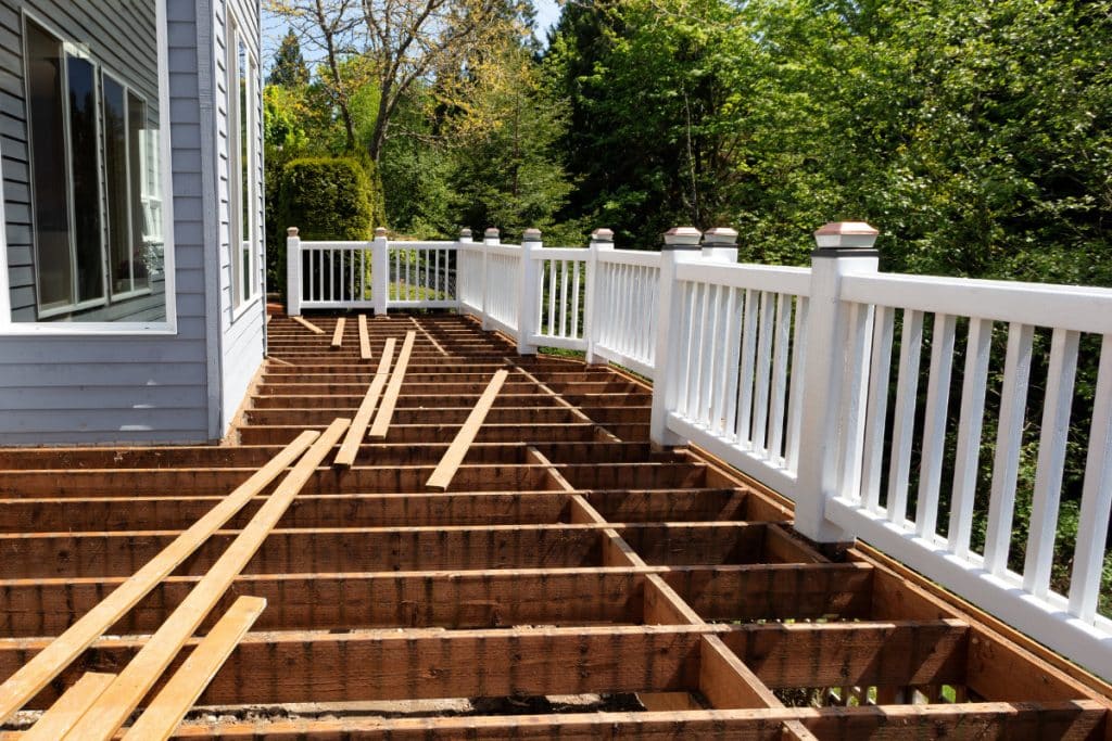 Professional deck repair crew with proper tools and safety equipment working on structural repairs Professional deck repair crew with proper tools and safety equipment working on structural repairs